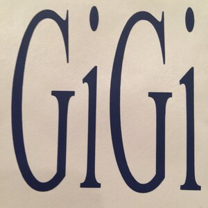 Op de afbeelding: Een close-up van een wit oppervlak met de naam "Gigi" geschreven in donkerblauwe letters.