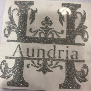 May include: Silver glitter monogram decal with the letter "H" and the name "Aundria" below. The letter "H" is decorated with ornate floral designs.