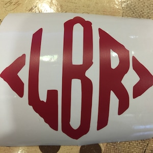 May include: A red monogram decal with the letters "LBR" in a diamond shape. The letters are outlined in white and have a slightly distressed look.