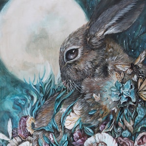 May include: A painting of a brown rabbit with a large, white moon in the background. The rabbit is surrounded by blue and green foliage and flowers. The painting has a whimsical and ethereal feel.