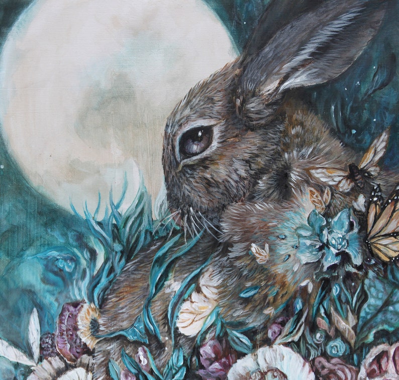 May include: A painting of a brown rabbit with a large, white moon in the background. The rabbit is surrounded by blue and green foliage and flowers. The painting has a whimsical and ethereal feel.