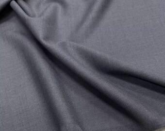 May include: A close-up shot of a gray fabric with soft folds and a subtle texture. The material appears to be a medium-weight textile, possibly suitable for clothing or home decor projects. The color is a muted, neutral gray.