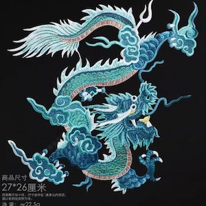Peut inclure: Un dragon brodé bleu et vert avec une queue blanche et bleu clair. Le dragon est enroulé en cercle avec sa tête tournée vers la droite. Le dragon est sur un fond noir. Le texte "商品尺寸 27*26厘米" est visible dans le coin inférieur gauche de l'image.