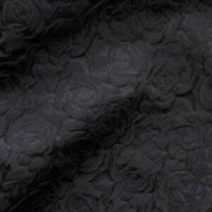May include: Black fabric with a raised rose pattern. The fabric is textured and has a soft, velvety feel.