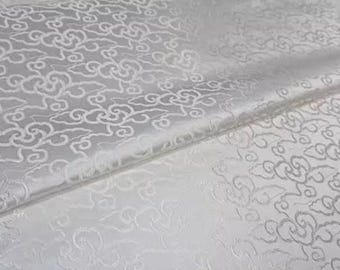 May include: White fabric with a repeating pattern of stylized clouds. The fabric has a subtle sheen and a slightly textured surface.
