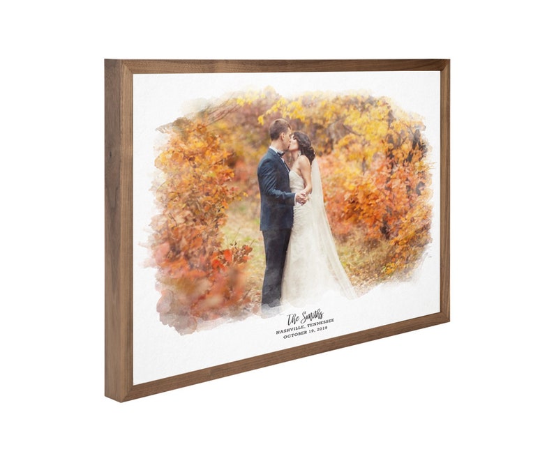 May include: A watercolor painting of a couple kissing in a fall forest. The painting is framed in a brown wood frame. The text "The Smiths" is written below the image, along with the date "October 18, 2019" and the location "Nashville, Tennessee".