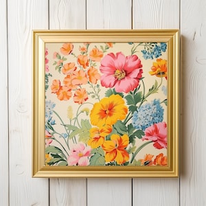 May include: A gold framed picture with a floral print. The print features pink, yellow, and red flowers on a white background.