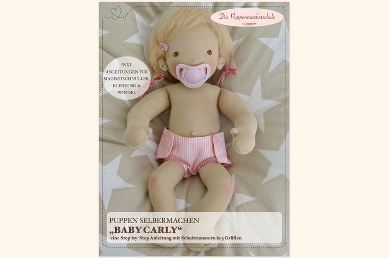 May include: A handmade doll pattern for a baby doll named "Baby Carly". The pattern includes instructions for making the doll, magnetic pacifier, clothing, and diaper. The doll is lying on a star-patterned fabric.