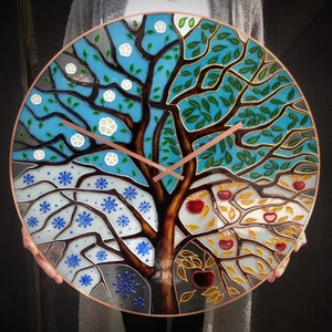 Stunning 24" stained glass clock with a four-season tree design. Perfect for those who love unique, oversized clocks that also serve as contemporary wall art. A stylish addition to your living room, dining area, or office decor.
