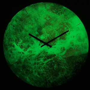 May include: A green glow-in-the-dark clock with black hands. The clock face is a stylised image of the Earth.