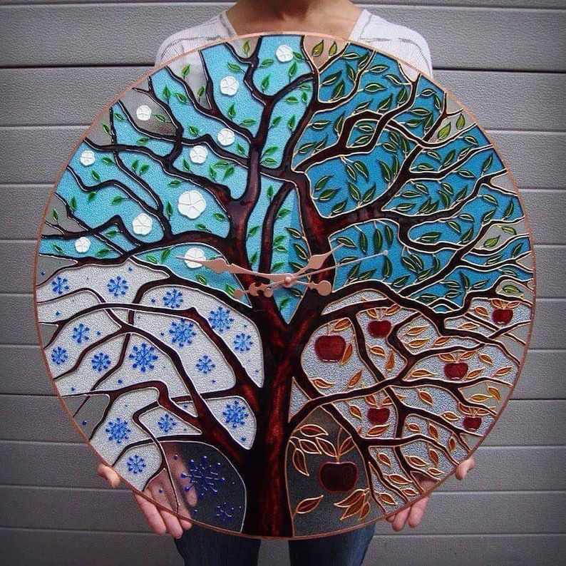 24-inch wall clock featuring a tree design that represents all four seasons. Hand-painted on stained glass, this oversized clock is perfect for modern homes, adding a touch of nature-inspired art to any room. Silent and ideal for living rooms.