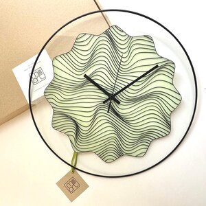 Artistic glass wall clock with a hand-painted design of magic waves. This glow-in-the-dark oversized clock features elegant black finishing, ideal for adding a bohemian touch to any space while keeping time stylishly. Unusual wall clock.Quirky clock.