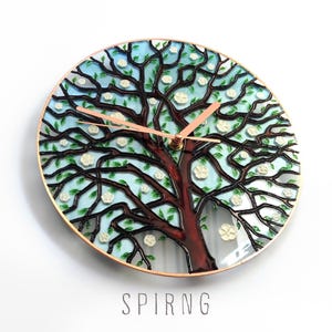Spring Tree of Life glass wall clock featuring blooming branches and hand painted seasonal details in turquoise and soft colors