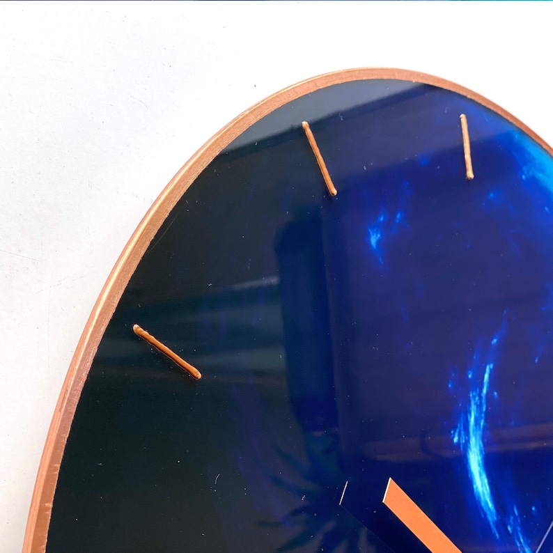Gorgeous Neptune wall clock designed with a beautiful blue glass finish. This large clock adds sophistication to your decor while celebrating the Pisces sign, making it a thoughtful gift for any astrology lover. Oversize wall clock. Blue wall decor.