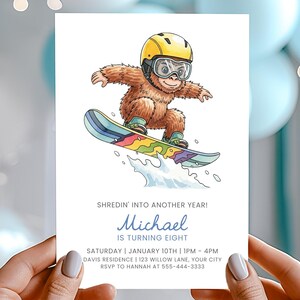 May include: A white invitation card featuring a cartoon yeti snowboarding. The yeti wears a yellow helmet and goggles. Text reads "Shredin' into another year!" and "Michael is turning eight."