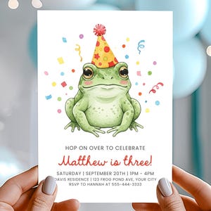 Puede incluir: Una invitación de cumpleaños con una ilustración en acuarela de una rana verde con un gorro de fiesta. La invitación dice "Hop on over to celebrate Matthew is three!" con detalles del evento. Confeti colorido rodea la rana.