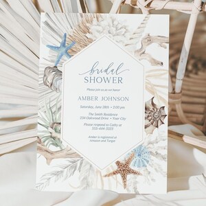 May include: A white card with a watercolor design of seashells, starfish, and palm leaves. The text on the card reads "bridal shower" and "Amber Johnson".