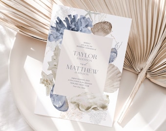 May include: A wedding invitation with a watercolor design of seashells and coral in shades of blue and beige. The invitation reads "And so we invite you to a timeless celebration of Taylor Anderson and Matthew Johnson August fourteenth, two thousand twenty-two at four o'clock in the afternoon Your City, State"