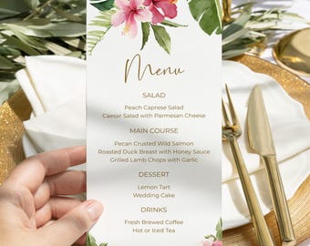 May include: A menu card with a floral design featuring pink hibiscus flowers and green leaves. The menu includes sections for salad, main course, dessert, and drinks. Gold cutlery and a gold-rimmed plate are also visible.
