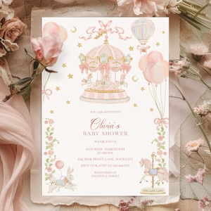 Op de afbeelding: Een roze en gouden babyshower uitnodiging met een aquarel illustratie van een draaimolen met een luchtballon en sterren. De tekst luidt: "U bent uitgenodigd voor Olivia's babyshower, Doe mee zaterdag 14 maart om 14:00 uur 624 Pink Peony Lane, Uw stad RSVP naar Kathy op 222-444-555 Geregistreerd bij Amazon & Target"