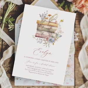 May include: A white invitation card with a stack of books decorated with flowers. The text on the card reads "Evelyn is starting a new chapter in her life! Join us for a bridal shower. Saturday, August 15th at 6PM. 8024 Marigold Lane, Your City, State. Text your RSVP to 555-444-3553. Registered at Amazon & Target."