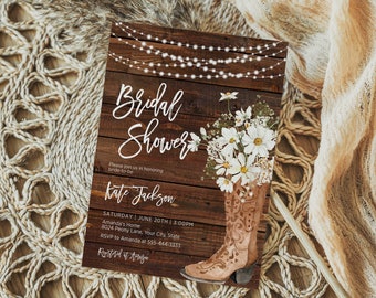 Pode incluir: Um convite rústico para um chá de panela com um fundo de madeira marrom, luzes brancas de corda e um arranjo floral em uma bota de cowboy marrom. O texto diz "Bridal Shower" e "Kate Jackson".