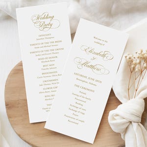May include: Two white wedding programme cards with gold foil lettering. One card lists the wedding party, while the other displays the names Elizabeth and Matthew, the date June 28th, and the ceremony order, including prelude, vows, and rings.