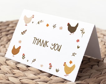 Puede incluir: Una tarjeta blanca con un borde marrón y un diseño floral. La tarjeta dice "Gracias" en letra cursiva marrón. Hay tres pollos en la tarjeta, uno blanco, uno marrón y uno amarillo.