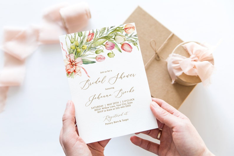 May include: A white bridal shower invitation with a watercolor floral design featuring pink and green flowers. The invitation text reads "Join us for a Bridal Shower honoring Johanna Brooks. Saturday, May 20th, 3 o'clock, 90241 Willow Lane, Your City, State. RSVP to Katie at 555-444-3333. Registered at Pottery Barn & Target."