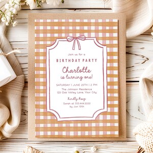 May include: A birthday party invitation with a pink and tan gingham pattern background. The invitation features a decorative frame with the text "Join us for a Birthday Party" and "Charlotte is turning one!" The invitation is on a brown envelope.