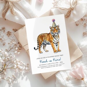 May include: A white invitation card featuring a watercolor illustration of a tiger wearing a party hat. The text reads "Join us for a roaring good time! Noah is Nine!" with event details. The card is on a neutral background.