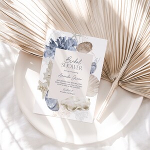 K&ouml;nnte beinhalten: Eine hellblaue und wei&szlig;e Einladung zur Brautparty mit einem Aquarell-Muschel-Design. Die Einladung lautet "Bridal Shower" und "Amanda Greene".