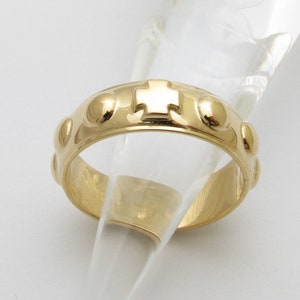 Peut inclure: Une bague en or avec une croix et de petites perles autour de la bande.
