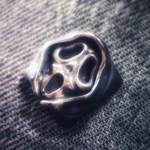 May include: A silver-toned metal pendant with a unique abstract design. The pendant has a textured surface and a three-dimensional shape.