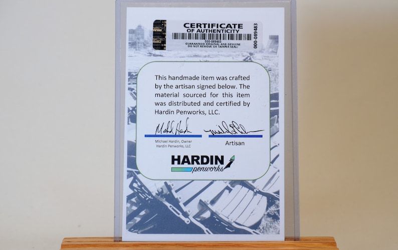 May include: A certificate of authenticity for a handmade item. The certificate is in a clear plastic holder and features the Hardin Penworks, LLC logo, signatures, and text. The background has a blue and white design.