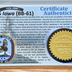 Puede incluir: Certificado de autenticidad para el USS Iowa (BB-61), un acorazado retirado. El certificado presenta texto sobre la historia del barco, un emblema del barco y un sello dorado con el texto "OFFICIAL MEMORABILIA".