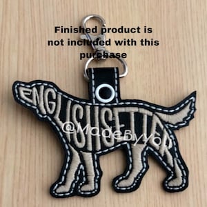 May include: Black leather keychain with a beige embroidered English Setter dog silhouette. The dog's name is embroidered on the silhouette. The keychain has a silver metal ring and a silver metal clasp.