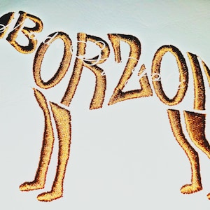 May include: A gold embroidered design of a Borzoi dog. The dog's silhouette is formed by the letters of the word "Borzoi".