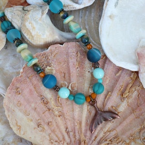 Copper whale tail pendant necklace in aqua, jade, green, turquoise and brown glass beads.  Earrings listed separately.