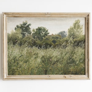 May include: A framed painting depicting a landscape with a field of green grass and trees in the background. The painting is in a light wood frame.