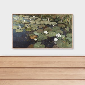 May include: A framed painting of a pond with white water lilies and green lily pads. The water is a dark blue color and the background is a light green.