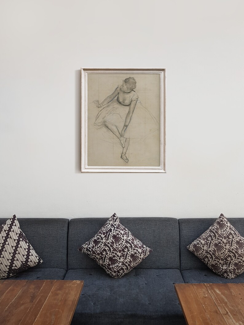 May include: A framed black and white drawing of a ballerina in a white tutu, sitting and tying her shoe.