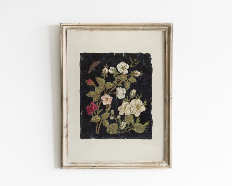 以下が含まれることがあります： 黒いベルベットの背景に花柄の刺繍が施された額装されたアート作品。刺繍は、白い花とピンクの花がついた緑の葉の枝を表しています。