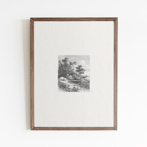 May include: A black and white framed print of a landscape scene with trees and a body of water. The print is in a simple wooden frame.