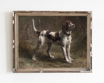 Op de afbeelding: Een ingelijst olieverfschilderij van een bruine en witte hond die op een grasveld staat. De hond kijkt naar rechts in het beeld.