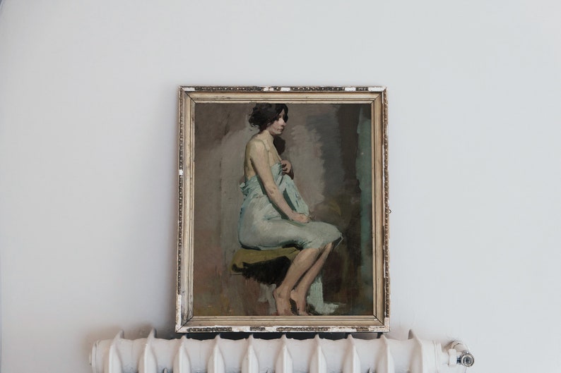 May include: A framed painting of a woman in a light blue draped garment, sitting on a stool. The painting is in a gold frame with a distressed finish.