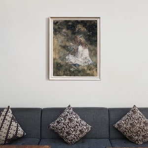 May include: A framed painting of a young girl in a white dress sitting in a field of flowers. The painting is done in a watercolor style and has a soft, dreamy feel.