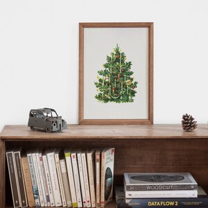 May include: A framed print of a vintage Christmas tree with ornaments and lights on a wooden shelf with books and a toy car.