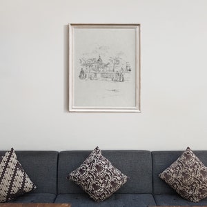 May include: A framed black and white sketch of a city scene with a domed building in the background. The sketch is on a light gray background and is framed in a white frame.