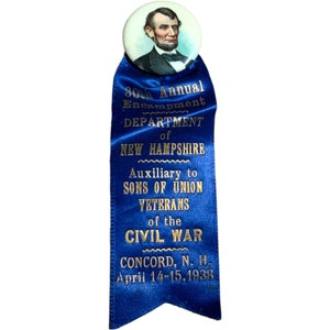 Puede incluir: Una cinta azul vintage con letras doradas y un alfiler circular con un retrato de Abraham Lincoln. La cinta dice "30º Campamento Anual, Departamento de New Hampshire, Auxiliar de Hijos de Veteranos de la Guerra Civil, Concord, N.H., 14-15 de abril de 1938."
